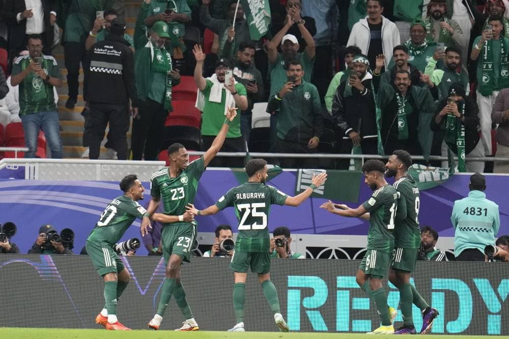 Saudi Arabia's Mohammed Kanno, second left, celebrates with teammates after scoring the opening goal of his team during the Asian Cup Group F soccer match between Kyrgyzstan and Saudi Arabia at Ahmad Bin Ali Stadium, in Doha, Qatar, Sunday, Jan. 21, 2024. (AP Photo/Aijaz Rahi)