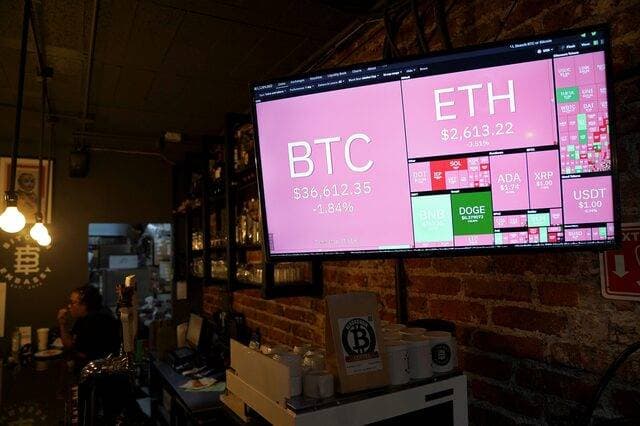  شاشة توضح تقلبات العملات المشفرة الافتراضية "Bitcoin" و"Ether" و"Doge" . رويترز