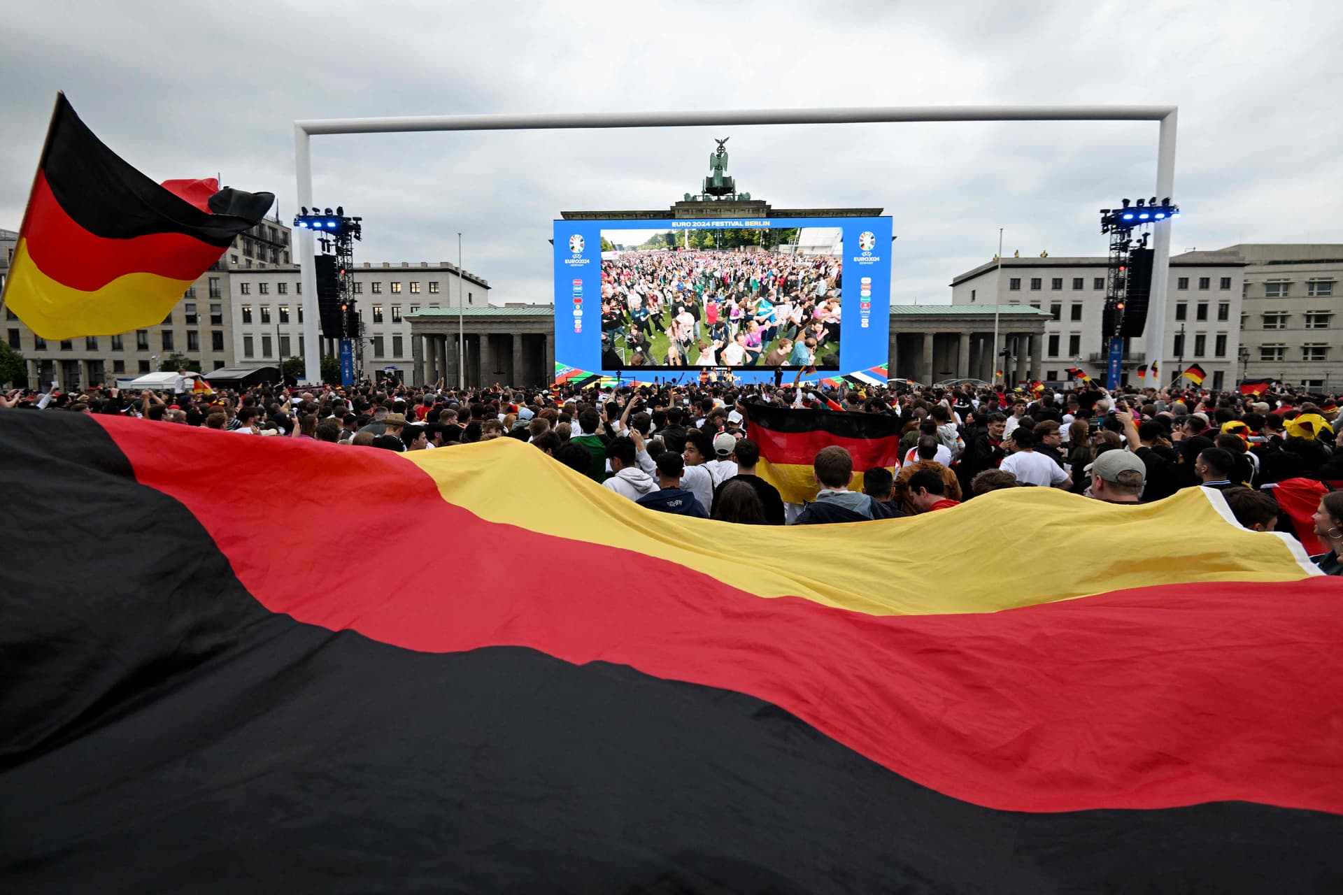 مشجعين يتابعون المباراة الافتتاحية لكأس الأمم الأوروبية عبر شاشة عملاقة. الفرنسية