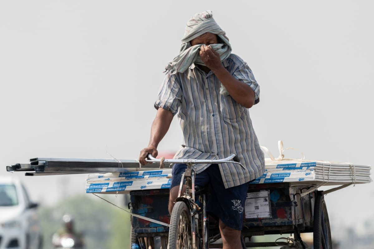 عامل ينقل مستلزمات بناء على دراجته في أحد الولايات الهندية. "بلومبرغ"