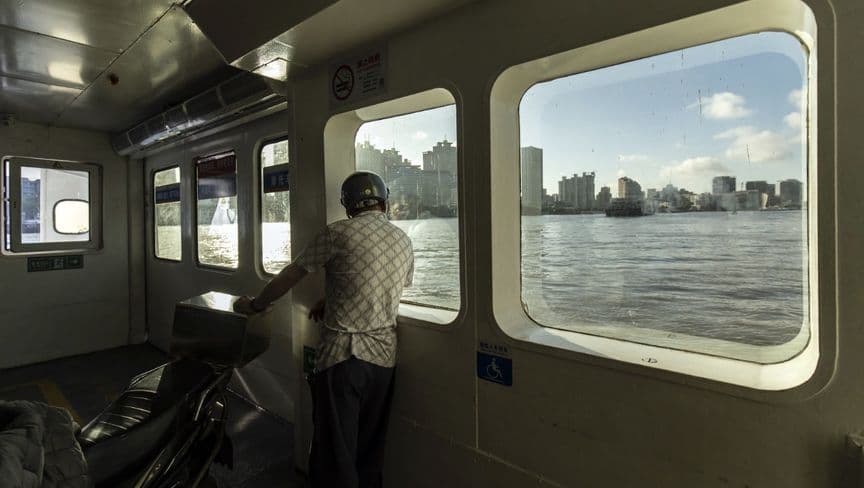 سائق سيارة يركب عبارة في شنغهاي، الصين - بلومبرغ