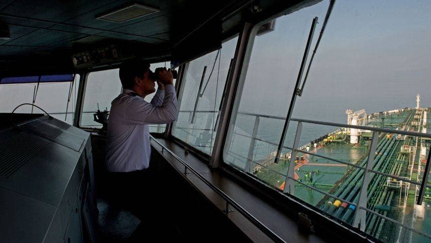 أحد أفراد طاقم الناقلة "ديفون" يستخدم منظارا أثناء استعدادها لنقل النفط في الخليج العربي. "بلومبرغ"