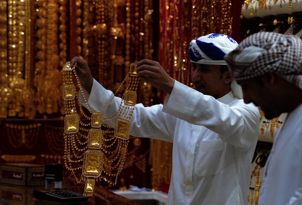 موظف يعرض مجوهرات ذهبية لأحد العملاء في متجر بسوق الذهب في دبي، الإمارات، 24 مارس 2018. رويترز