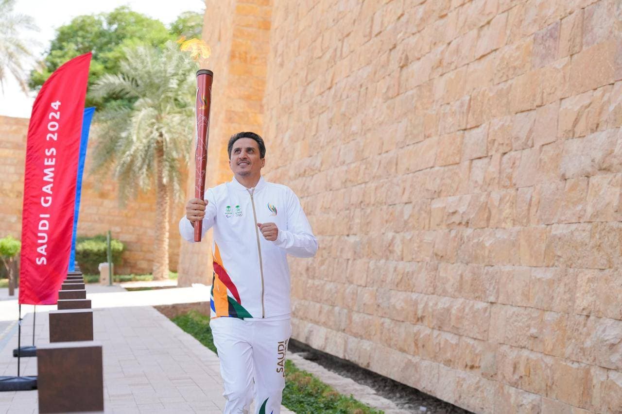 اللاعب السابق نواف التمياط خلال حمل شعلة دورة الألعاب السعودية.