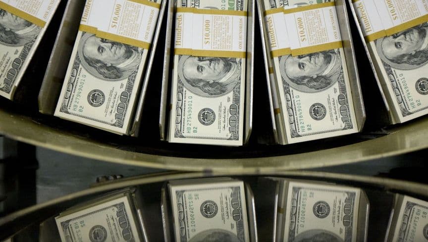 أوراق نقدية من فئة 100 دولار أمريكي تمر عبر ماكينة دائرية - المصدر: بلومبرغ