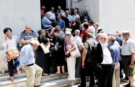 متقاعدون يونانيون ينتظرون أمام فرع مغلق لمصرف اليونان الوطني في أثينا التي تتضاعف معاناة متقاعديها بسبب أزمة البلاد المالية. جتي