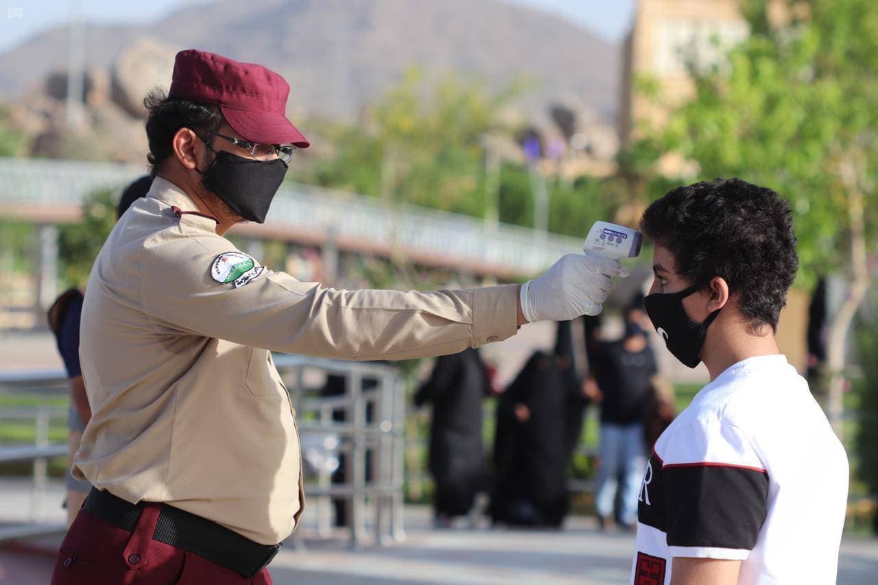 قياس درجة حرارة شاب على مدخل أحد المتنزهات ضمن الاإجراءات الاحترازية. "واس"
