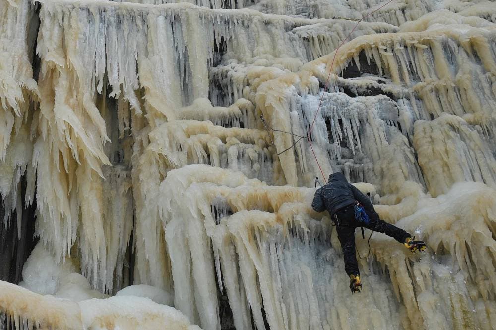متسلق جليدي يصعد كيندر داون فول، وهو شلال متجمد في حديقة بيك ديستريكت الوطنية بالقرب من هايفيلد، شمال غرب إنجلترا."الفرنسية"
