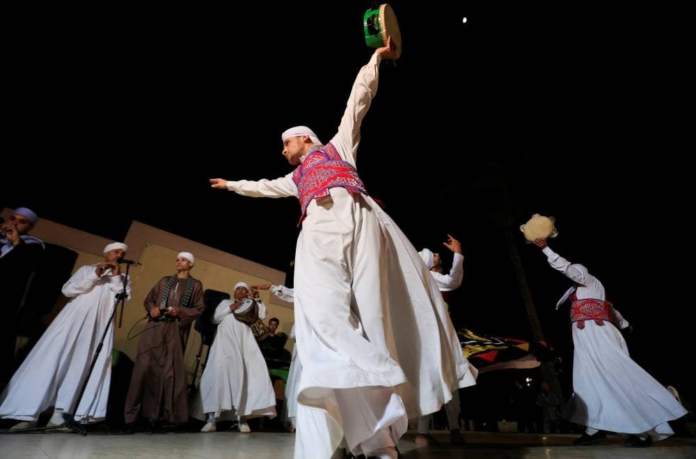 مصريون يؤدون رقصة التنورة خلال احتفال في القاهرة."