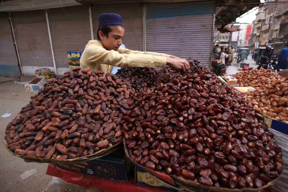 فتى باكستاني يعرض تمورا للبيع في أحد شوارع بيشاور، مع قرب حلول شهر رمضان » إ. ب. أ « .