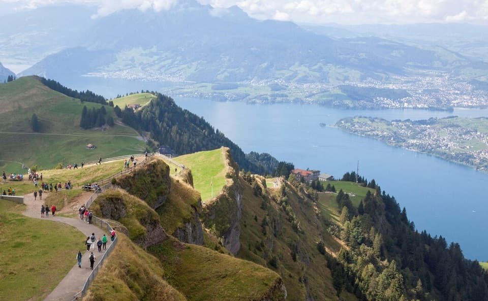 سياح يسيرون على قمة جبل ريجي بالقرب من بحيرة لوسيرن. رويترز