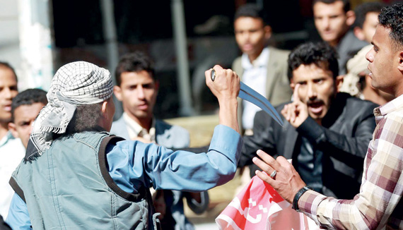 مسلح حوثي يهدد شبابا يمنيين خرجوا للتنديد بالاستيلاء على العاصمة صنعاء في وقت سابق.