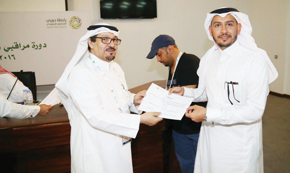 المهندس سلمان النمشان يقدم شهادة لأحد المشاركين في ورشة عمل مراقبي ومنسقي المباريات.