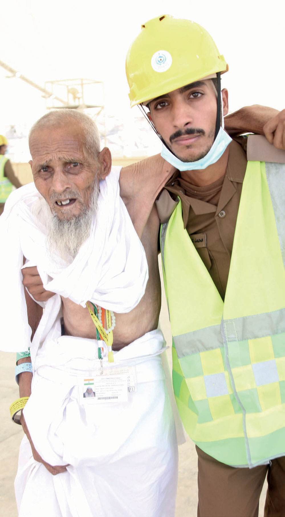 عجوز يستند إلى أحد أفراد الدفاع المدني للوصول إلى مراده.
تصوير: سلمان المرزوقي - «الاقتصادية»