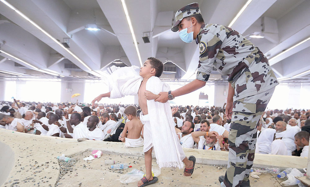 ..وهنا أحد أفراد الأمن يساعد طفل على رمي الجمرات.