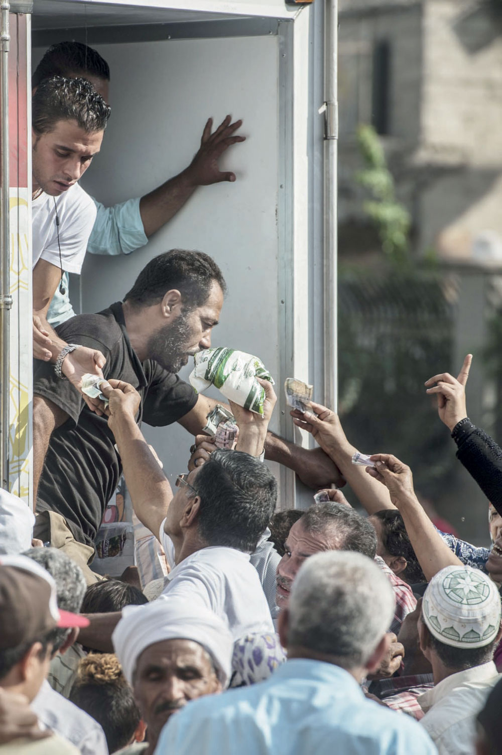 مواطنون مصريون يصطفون في طابور لشراء أكياس السكر المدعوم في القاهرة أمس، حيث هبط الجنيه إلى مستوى قياسي  مقابل الدولار . "الفرنسية"