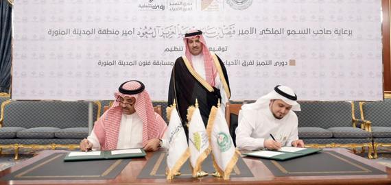 الأمير فيصل بن سلمان خلال توقيع اتفاقية تنظيم دوري التميز لفرق الأحياء."الاقتصادية"