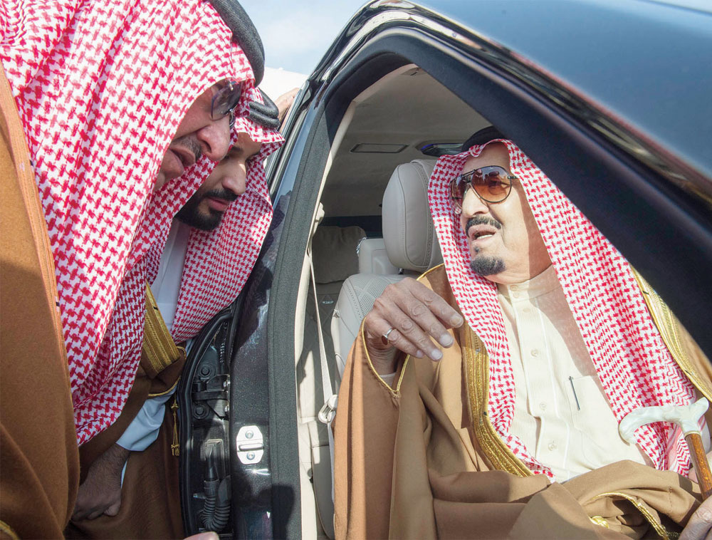 خادم الحرمين متحدثا لولي العهد وولي ولي العهد لدى وصوله إلى الرياض أمس، قادما من الكويت. تصوير: بندر الجلعود - "الاقتصادية"