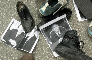 صور للرئيس الأمريكي جورج بوش ملقية على الأرض وعليها الأحذية في مسيرة احتجاج الى السفارة الأمريكية ( الفرنسية )