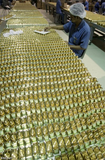 عمال يضعون اللمسات الأخيرة على زجاجات "عطور أجمل" في مصنعها في دبي.