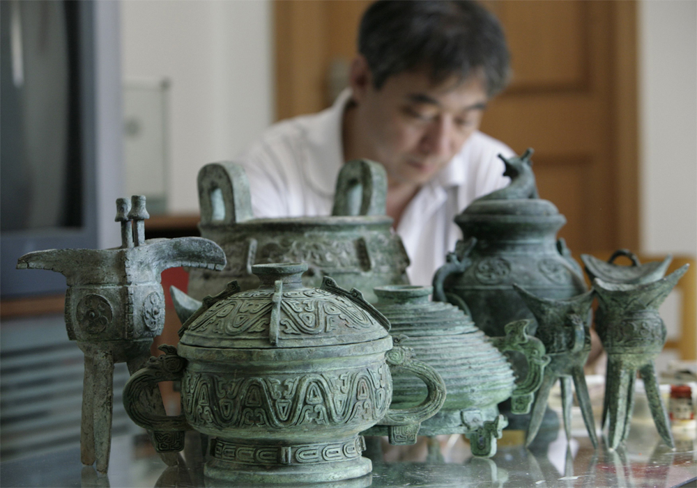 نماذج مقلدة من تماثيل برونزية أثرية مصنوعة من الورق يتم عرضها  على محبي الفنون الصينية في منزل الفنان ميهوا في بكين.