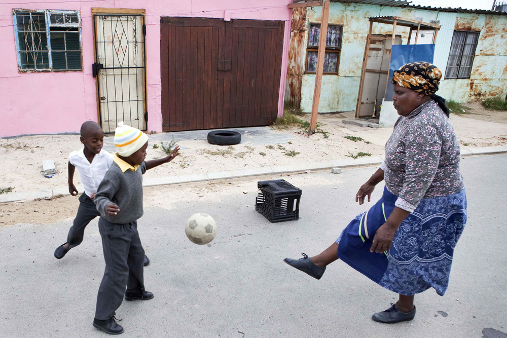 جنوب افريقية تلعب كرة القدم مع حفيدها بالقرب من منزلها في مدينة كيب تاون.
