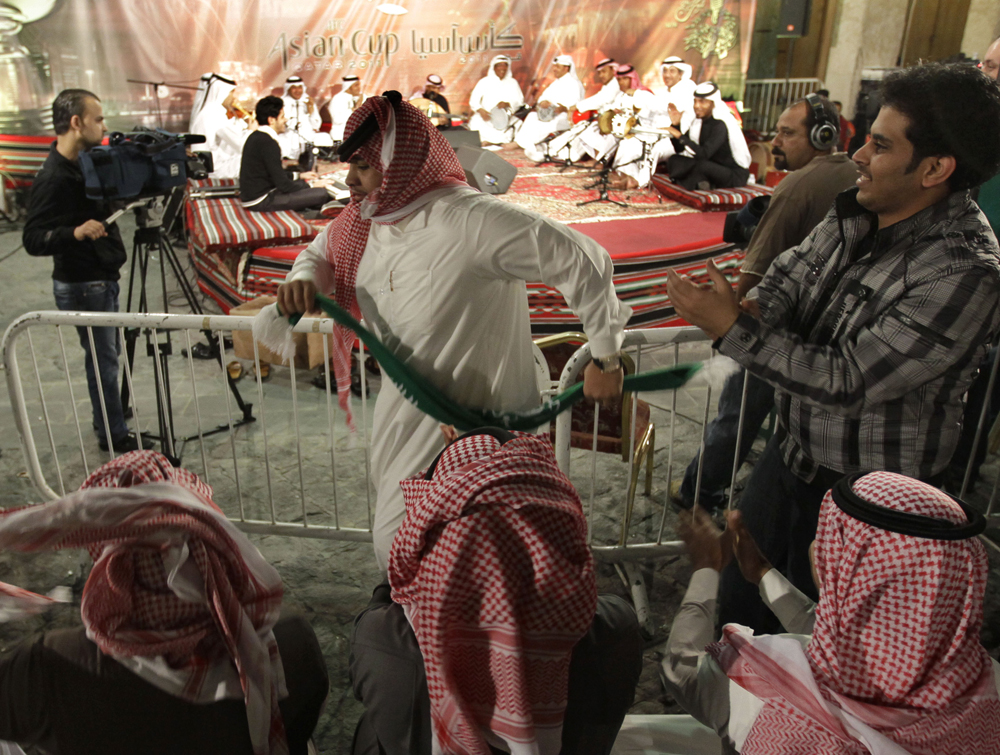 مشجع سعودي يرقص طربا على أنغام جلسة شعبية في سوق واجف في الدوحة انتظارا للمواجهة السعودية السورية في كأس آسيا