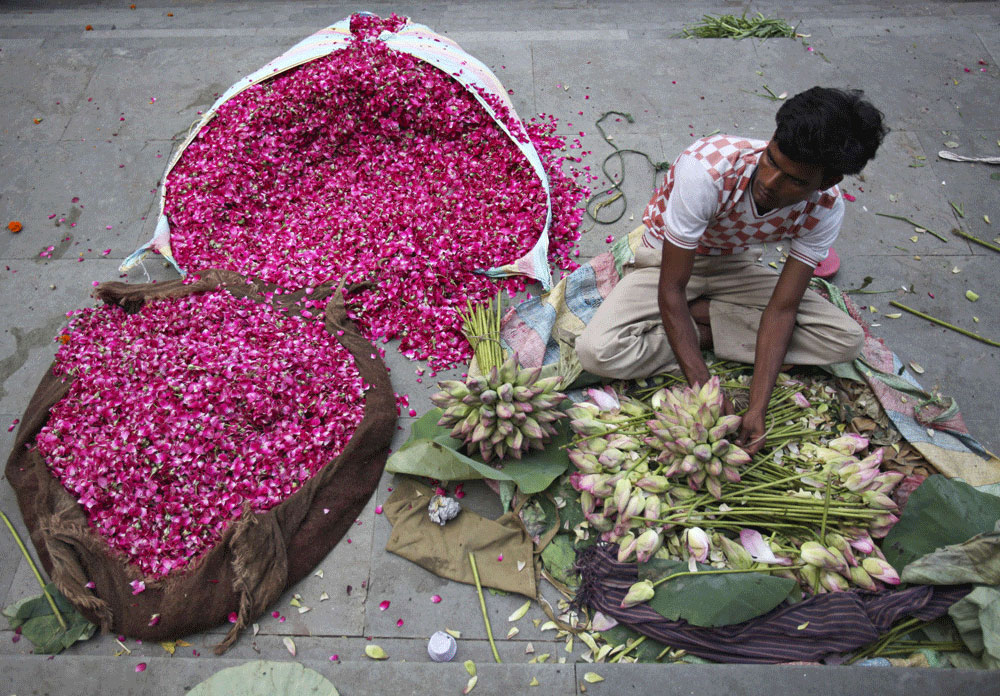 بائع هندي يقوم بتقطيع أوراق الزهور لبيعها في سوق الجملة في نيودلهي والذي يعتبر أكبر سوق في العالم لبيع الزهور