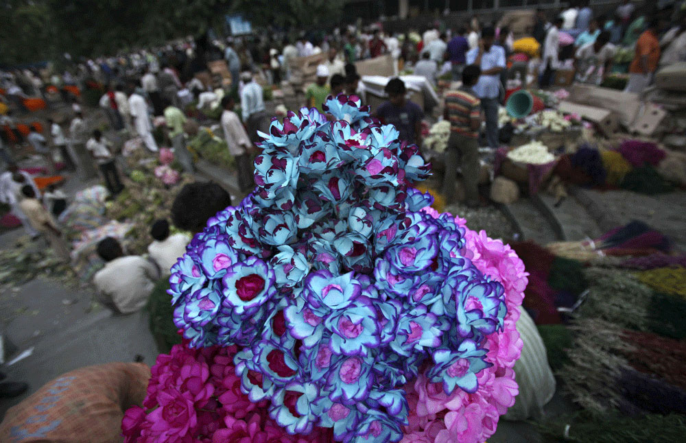 بائع هندي يقوم بتقطيع أوراق الزهور لبيعها في سوق الجملة في نيودلهي والذي يعتبر أكبر سوق في العالم لبيع الزهور