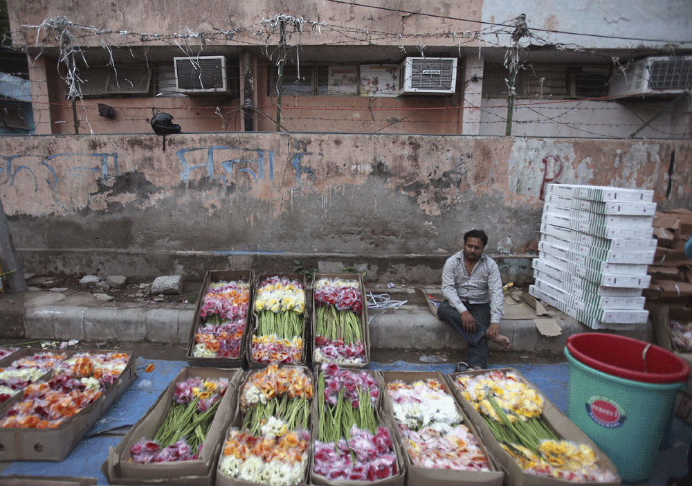 بائع هندي يقوم بتقطيع أوراق الزهور لبيعها في سوق الجملة في نيودلهي والذي يعتبر أكبر سوق في العالم لبيع الزهور