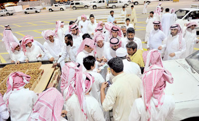 شباب سعوديون يعملون في حمل وتنزيل وبيع التمور لتحقيق دخل عال