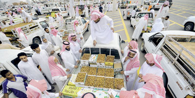 شباب سعوديون يعملون في حمل وتنزيل وبيع التمور لتحقيق دخل عال