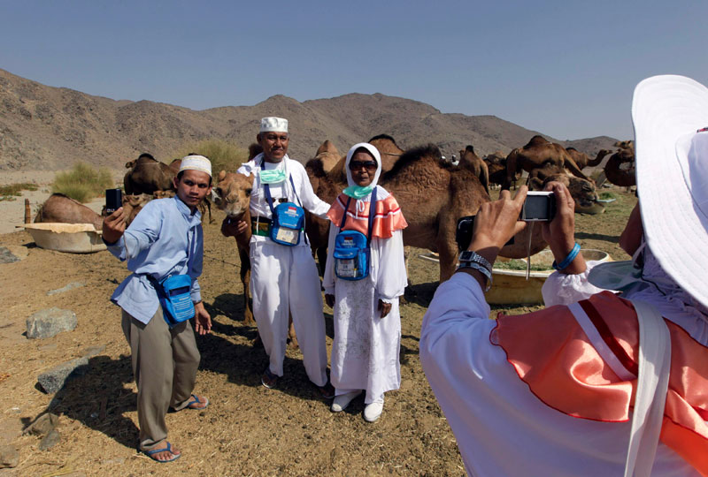 حجاج اندونيسيون يلتقطون صور تذكارية في مزرعة للإبل في مكة المكرمة