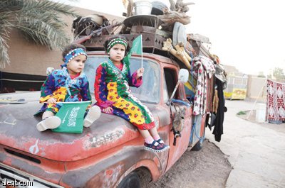 طفلتان تجلسان على مقدمة سيارة قديمة ''بطل الصحراء''