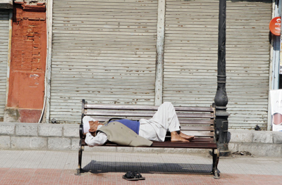 مسن يأخد قسطا من الراحة على مقعد في سوق مغلق في كشمير الهندية