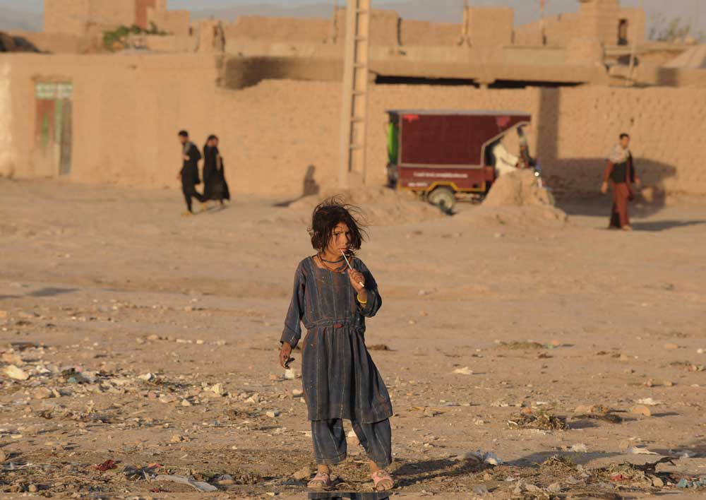 فتاة أفعانية تنتظر المساعدات الغذائية في مدينة هرات  ووفقا للبنك الدولي يعيش أكثر من ثلث السكان تحت خط الفقر .