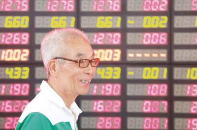 مستثمر يمر مبتسماً أمام شاشة رصد الأسعار داخل شركة أوراق مالية خاصة في منطقة شنغهاي الصينية أمس. وارتفع مؤشر الأسهم الآسيوية أمس