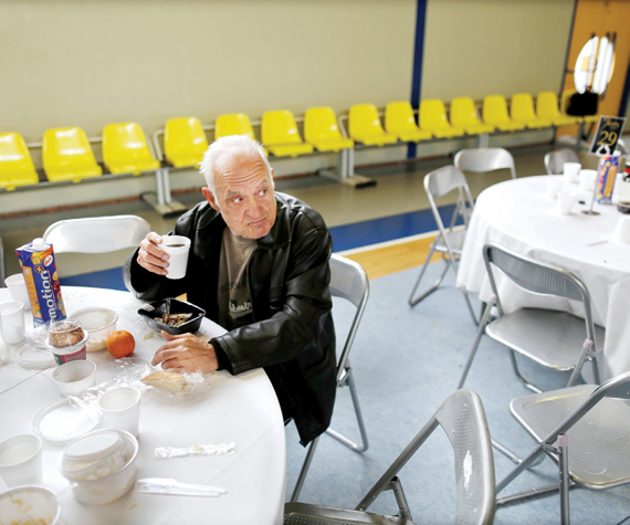 رجل بلا مأوى يتناول وجبة غذائية قدمتها بلدية أثينا أمس للمشردين والفقراء في المدينة في ظل الأزمة الاقتصادية التي تعصف باليونان