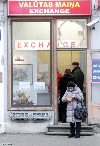 سيدة تقف أمام مكتب صرافة في ريغا