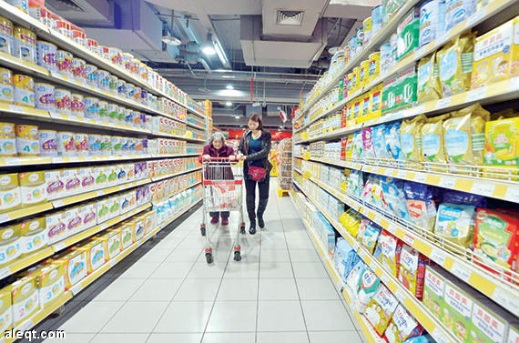 متسوقتان بين رفوف مليئة بالحليب في سوبر ماركت في تشونغتشينغ جنوب غرب الصين