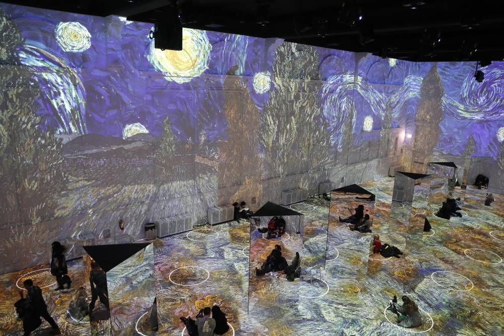 زوار معرض فضاء الفنون في شيكاغو الأمريكية يشاهدون عرضا افتراضيا لأعمال الفنان الهولندي فينسنت فان خوخ مع المحافظة على التباعد الاجتماعي. "أ. ب"