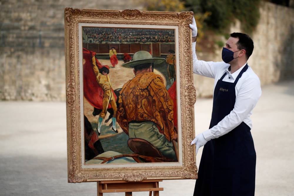 موظف دار مزاد سوثبي في باريس حاملا لوحة ماتادور في الساحة التي رسمها الرسام الفرنسي فرانسيس بيكابيا في 1941 قبل عرضها في مزاد علني. «الفرنسية »