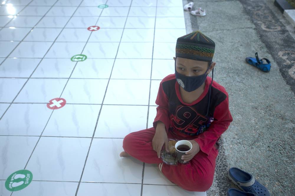 طفل إندونيسي في أحد مساجد بالي ينتظر الإطار.