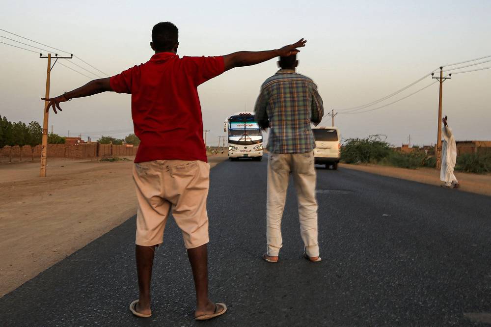 سودانيان يدعوان السائقين إلى الإفطار جنوب الخرطوم."الفرنسية"