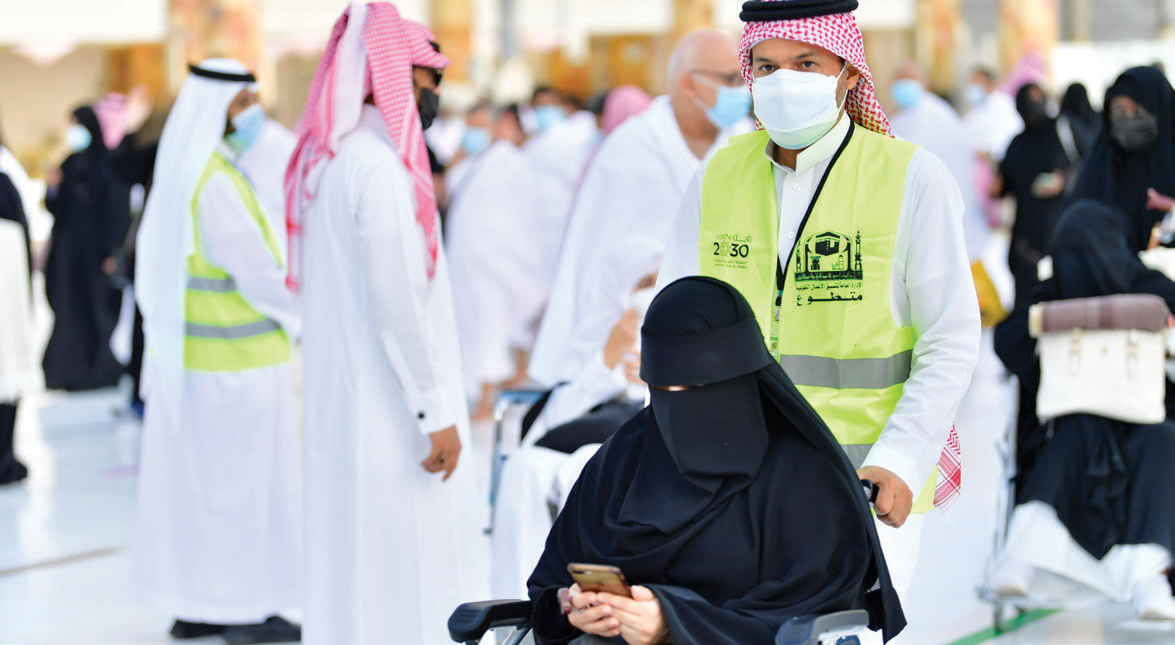 متطوع يساعد امرأة في المسجد الحرام. "واس"
