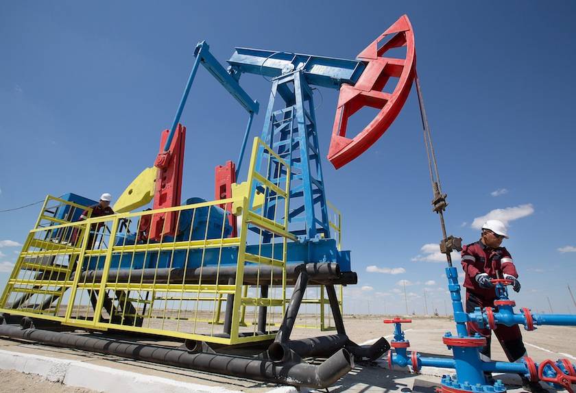 Workers perform maintenance on an oil pumping unit, also known as a "nodding donkey" at an oilfield operated by Embamunaigas, a unit of KazMunaiGas Exploration Production, in Akkystau village, near Atyrau, Kazakhstan, on Saturday, July 4, 2015. The majority Muslim country is central Asia's biggest oil producer. Photographer: Andrey Rudakov/Bloomberg