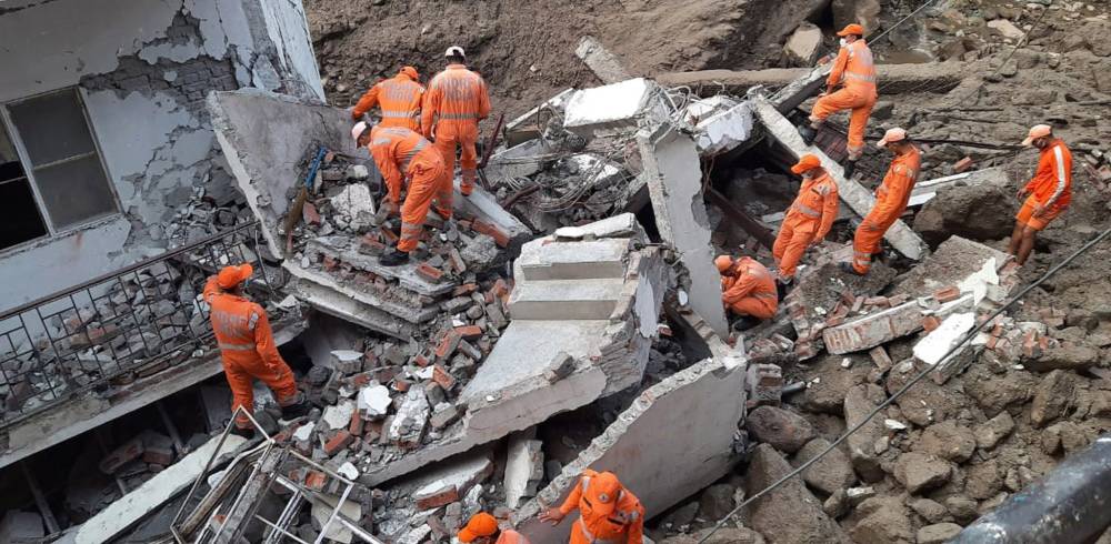 فريق إنقاذ يبحث عن ناجون في مبنى تدمر من جراء سيول الأمطار في منطقة أوتارانتشال الهندية. "إ ب أ"