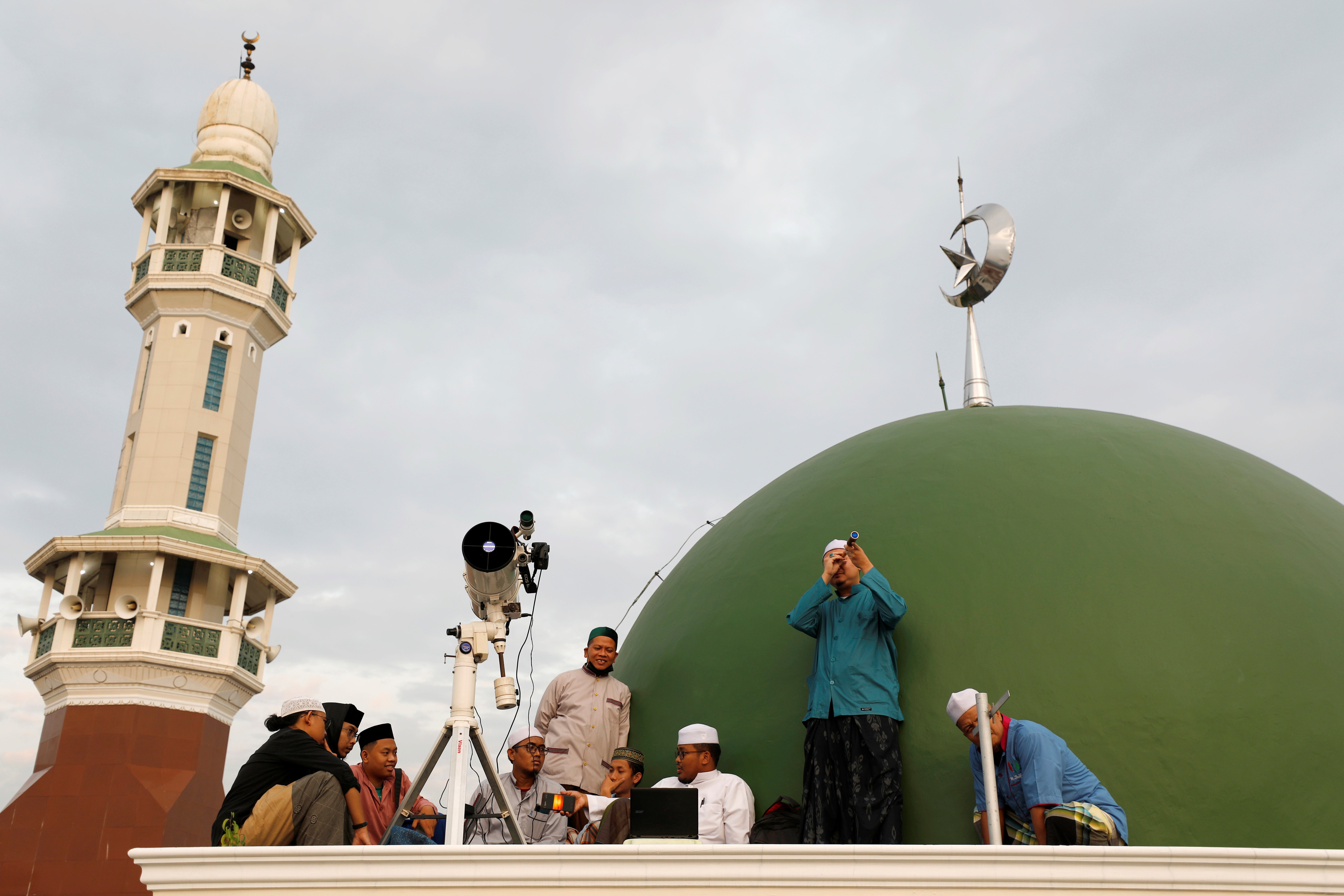 أشخاص يتحرون هلال شهر شوال في جاكرتا الإندونيسية. «رويترز »