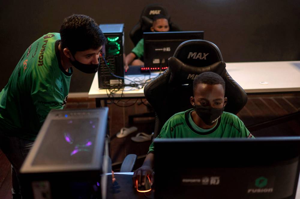 شباب برازيليون يمارسون ألعاب الفيديو في أحد احياء ريو دي جانيرو الفقيرة."الفرنسية"