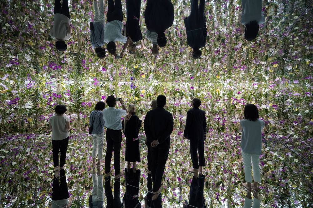 صحافيون يلقون نظرة على عمل فني يحمل اسم «حديقة الزهور العائمة »، المصمم من قبل مجموعة إبداعية يابانية، وذلك في متحف الفن الرقمي التفاعلي طوكيو. «إ. ب. أ »
